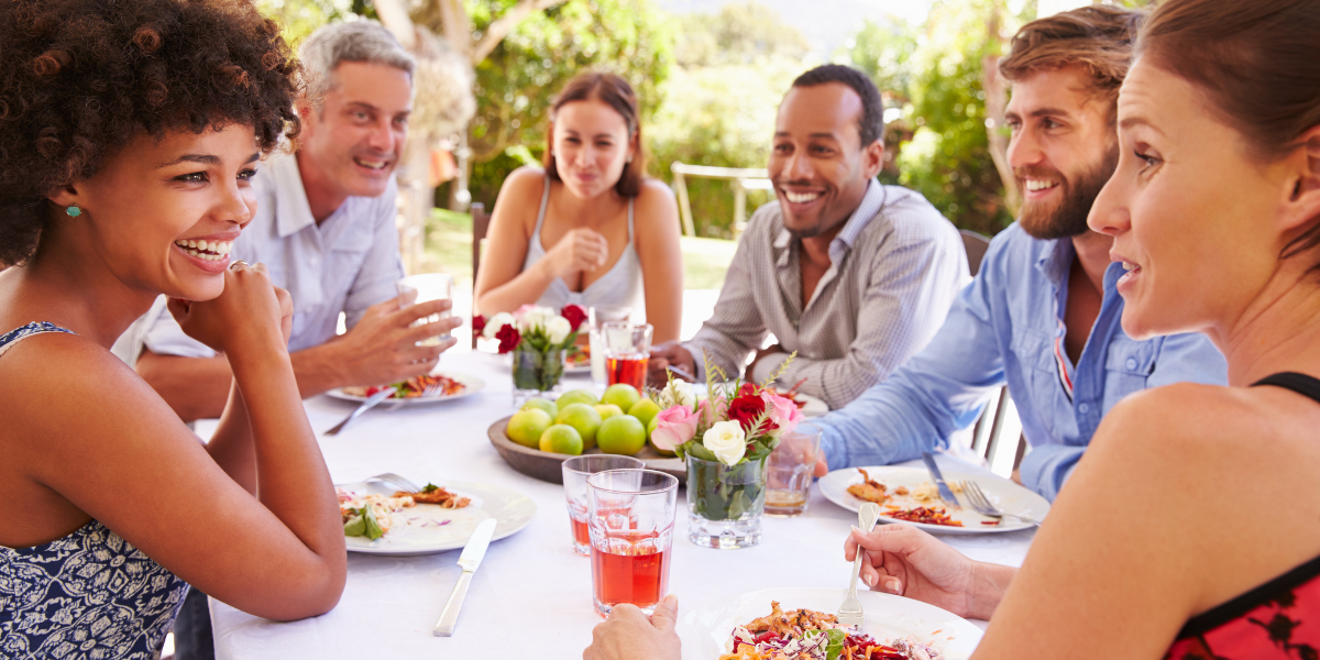 Happy guests dining outside in summer 